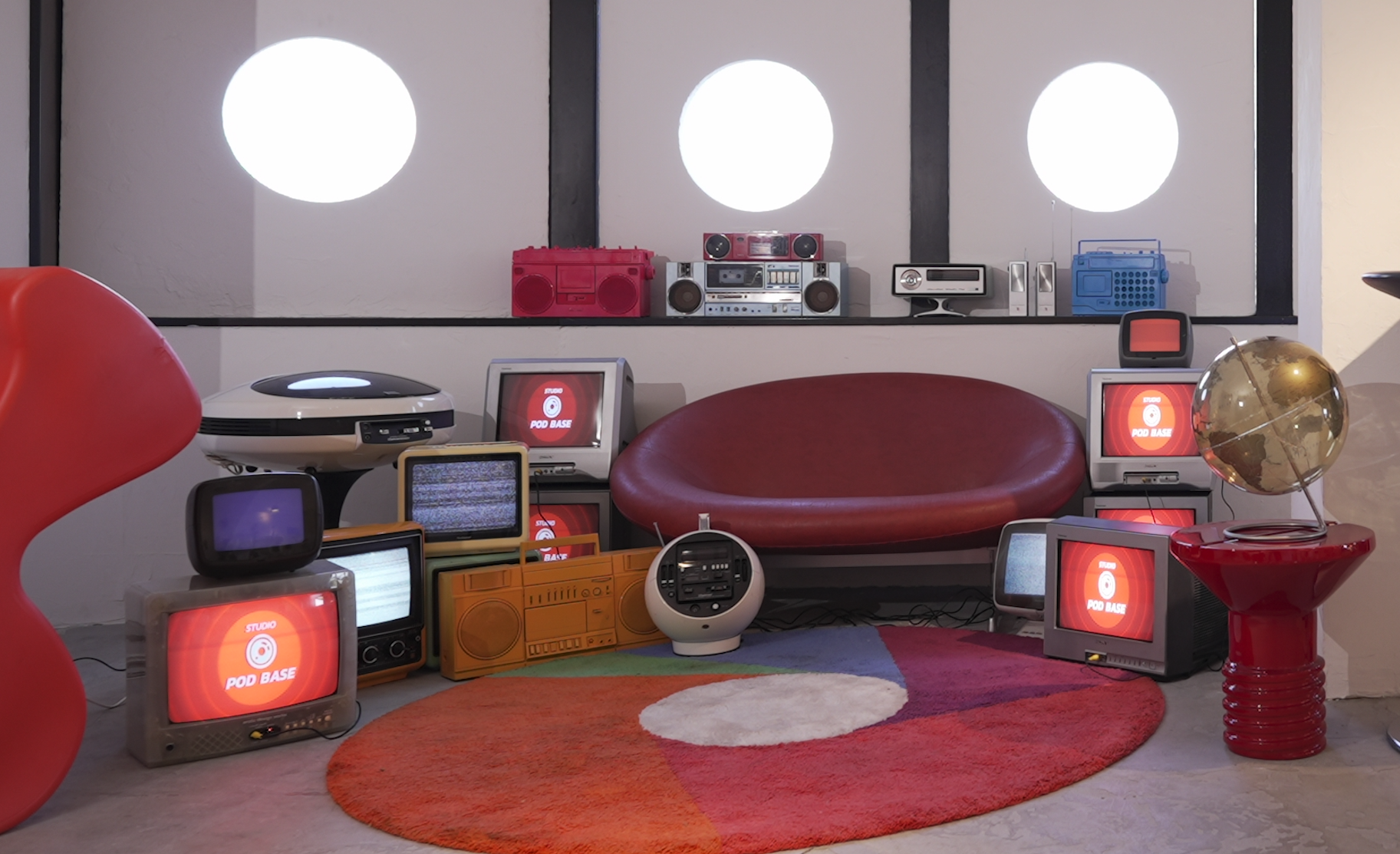 レトロポップ平和島のソファーエリア。ブラウン管テレビやラジカセ、小物を赤やシルバー、ブルーでまとめたセット写真