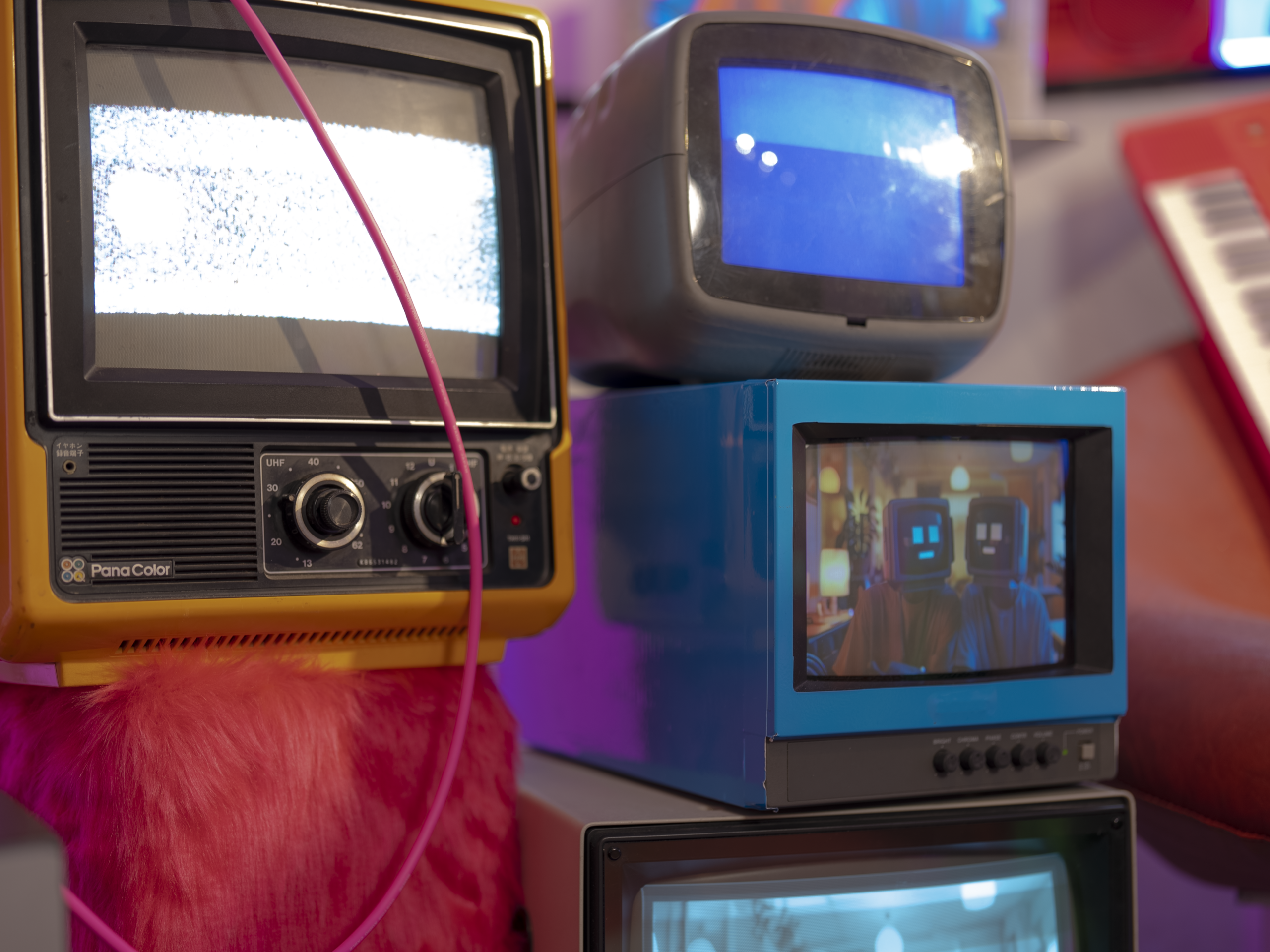 ファーで装飾した台の上にブラウン管テレビを重ねた、レトロポップ平和島の一角。色と素材の違和感が重なるセット写真