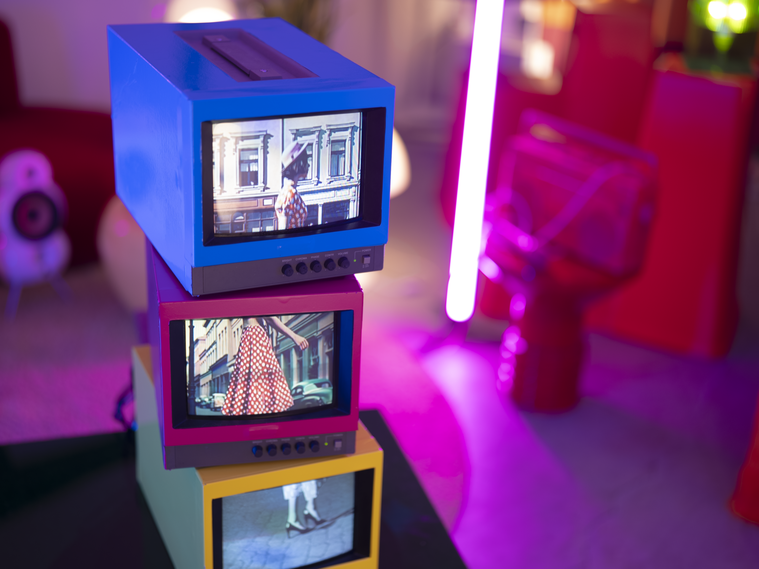 ブルーの台に3台のブラウン管テレビを重ねたセット。ピンクとブルーの照明が入った、レトロポップ平和島のブラウン管テレビエリア